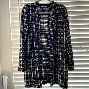 A black and white pleated trench coat.